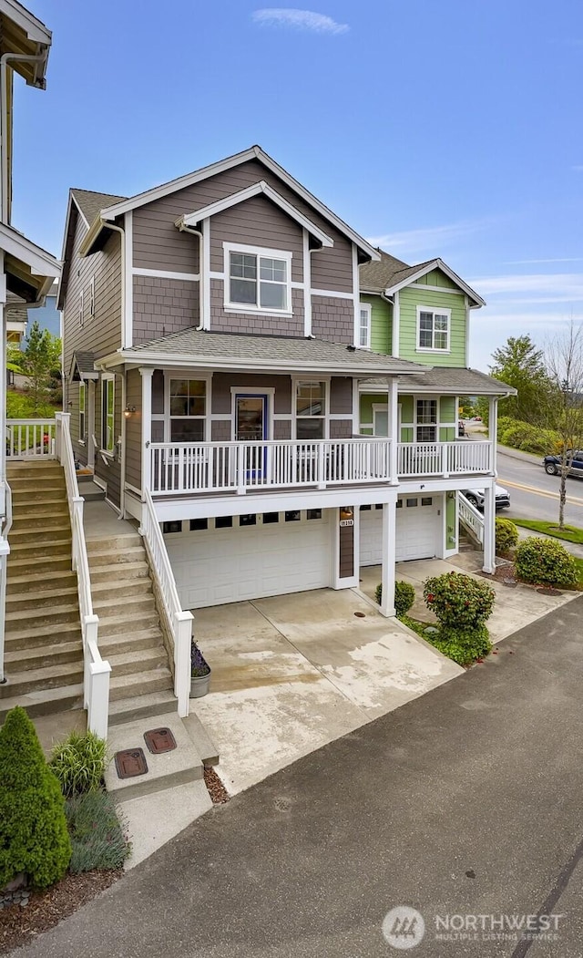 view of front of property with an attached garage, stairs, driveway, and a porch