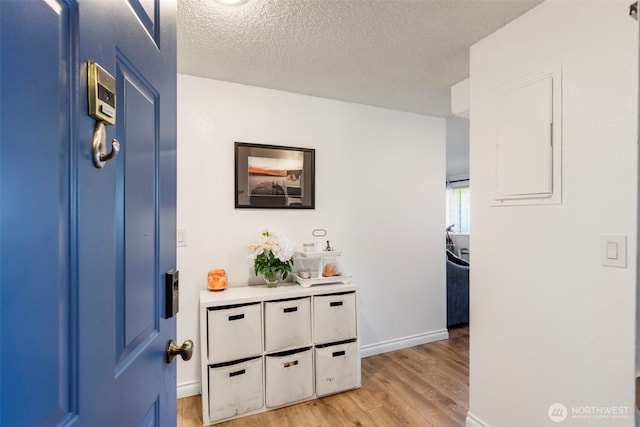 20145 Vikings Crest Loop NE Unit 3-105, Poulsbo, WA 98370 - hall featuring a textured ceiling, baseboards, and light wood-type flooring