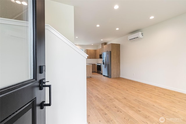 4230 Melrose Ln, Bellingham, WA 98226 - kitchen with stainless steel fridge, a wall mounted AC, recessed lighting, brown cabinetry, and light wood finished floors