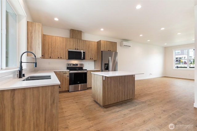 4230 Melrose Ln, Bellingham, WA 98226 - kitchen with appliances with stainless steel finishes, a kitchen island, an AC wall unit, recessed lighting, and light wood-type flooring