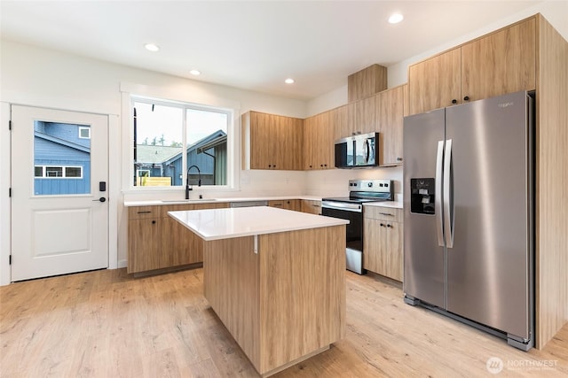 4230 Melrose Ln, Bellingham, WA 98226 - kitchen with appliances with stainless steel finishes, a kitchen island, light countertops, light wood-type flooring, and recessed lighting