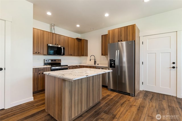 4232 Melrose Ln, Bellingham, WA 98226 - kitchen featuring appliances with stainless steel finishes, a center island, dark wood-style flooring, brown cabinets, and recessed lighting