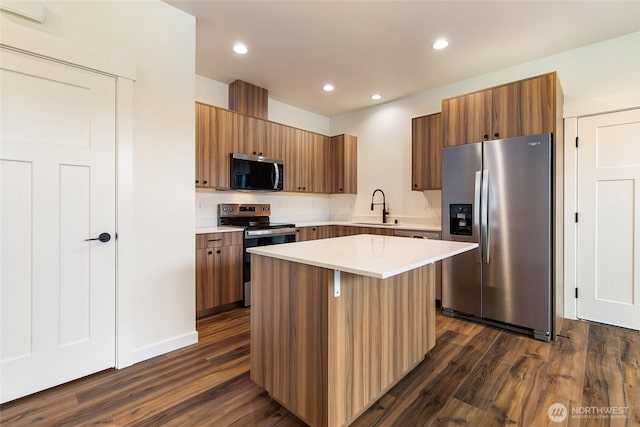 4232 Melrose Ln, Bellingham, WA 98226 - kitchen featuring stainless steel appliances, dark wood-type flooring, brown cabinetry, light countertops, and recessed lighting
