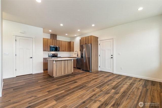 4232 Melrose Ln, Bellingham, WA 98226 - kitchen with appliances with stainless steel finishes, a kitchen island, dark wood-style floors, light countertops, and recessed lighting