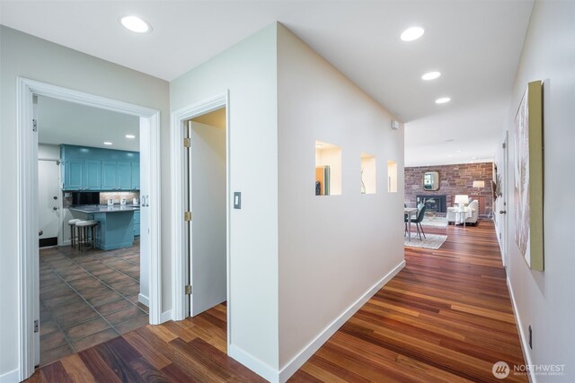 hall with recessed lighting, dark wood-style flooring, and baseboards