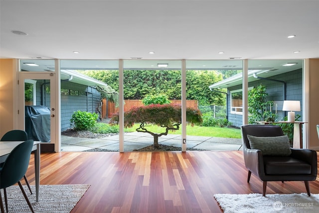 doorway to outside with wood finished floors and floor to ceiling windows