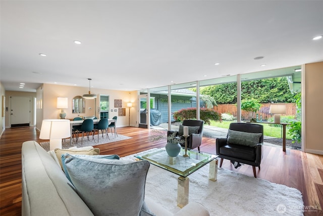 living room with light wood-style flooring, baseboards, and recessed lighting