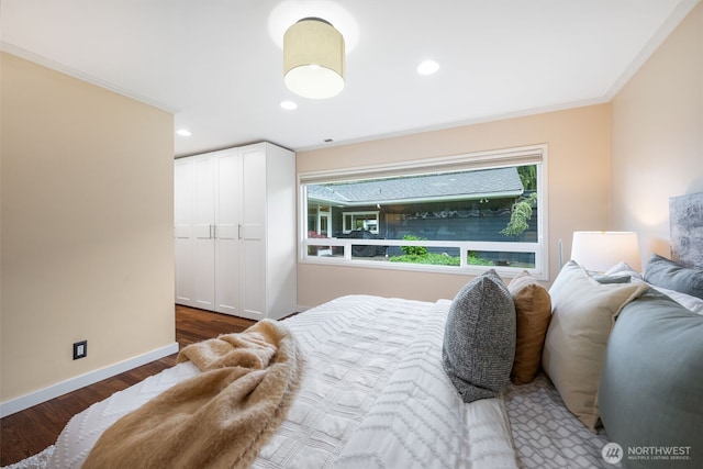 bedroom featuring wood finished floors, baseboards, crown molding, recessed lighting, and a closet