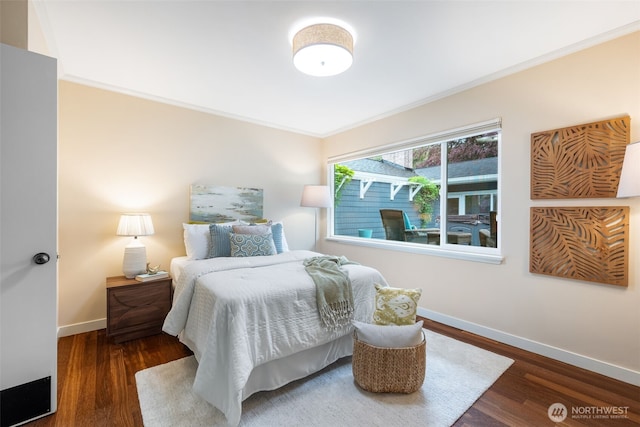 bedroom featuring crown molding, baseboards, and wood finished floors