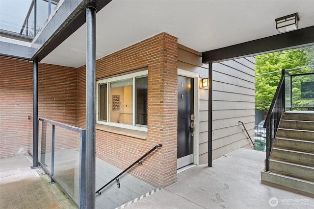view of home's exterior with stairway and brick siding