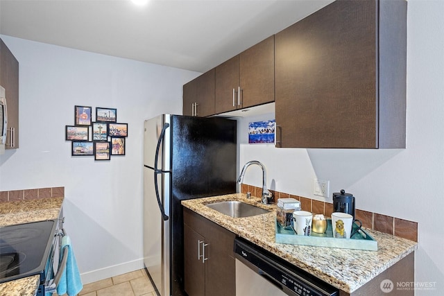 kitchen featuring baseboards, a sink, dark brown cabinets, and stainless steel appliances