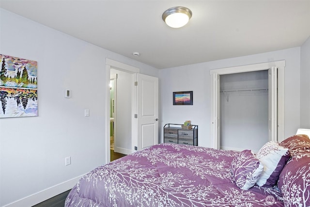 bedroom featuring baseboards, dark wood-type flooring, and a closet