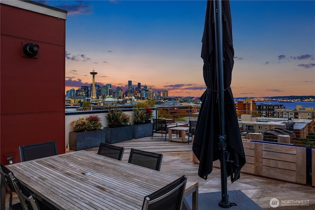 patio terrace at dusk with a view of city and outdoor dining space