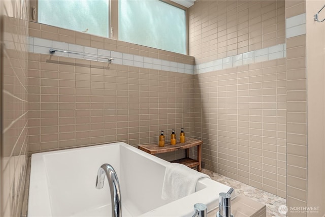 full bathroom with a tub to relax in and tile walls
