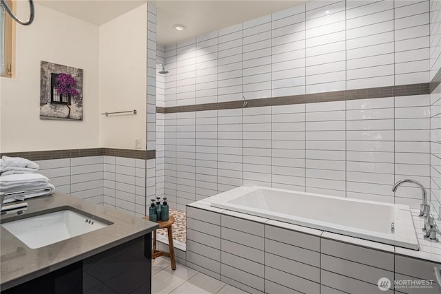 bathroom featuring tile patterned flooring, a sink, and tile walls