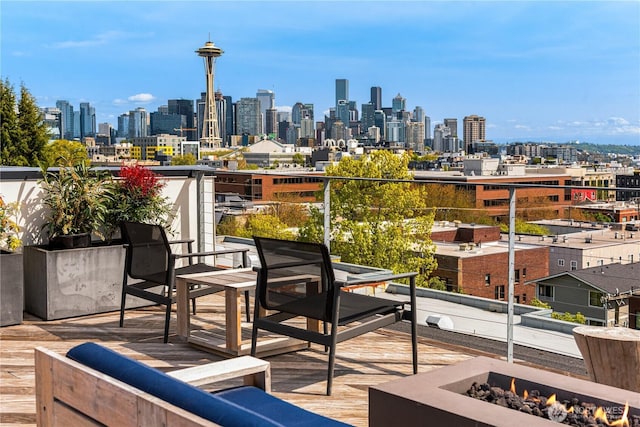 exterior space with a view of city, a fire pit, and a balcony