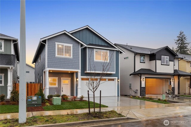 view of front of house with concrete driveway, an attached garage, fence, and board and batten siding