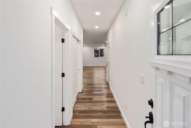 hall featuring baseboards, wood finished floors, and recessed lighting