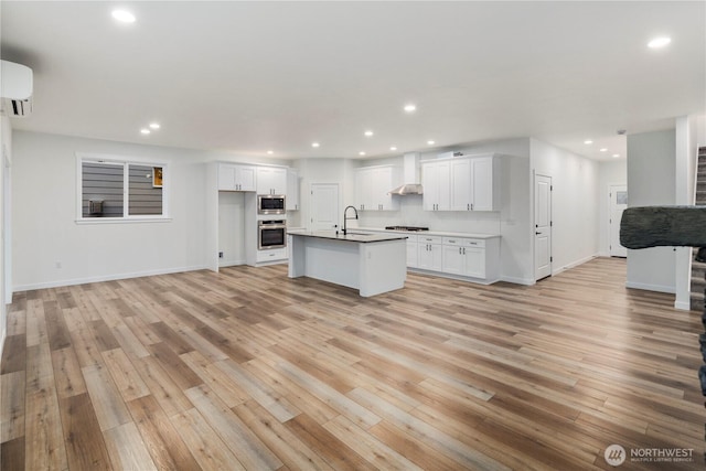 kitchen with open floor plan, stainless steel appliances, light wood finished floors, and recessed lighting