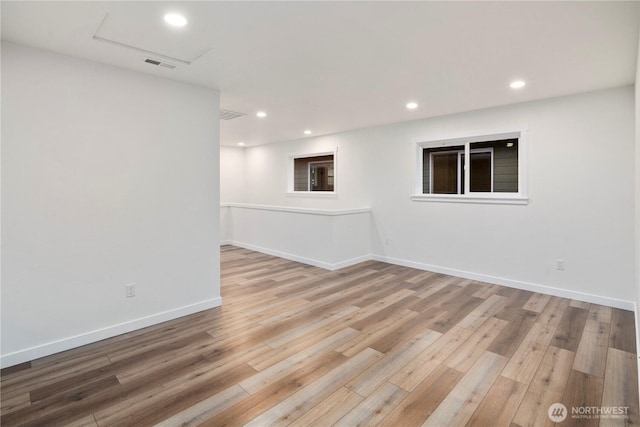 empty room featuring wood finished floors, visible vents, and recessed lighting