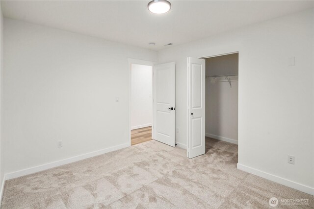 unfurnished bedroom with baseboards, carpet flooring, and a closet