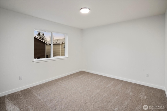 carpeted spare room featuring baseboards