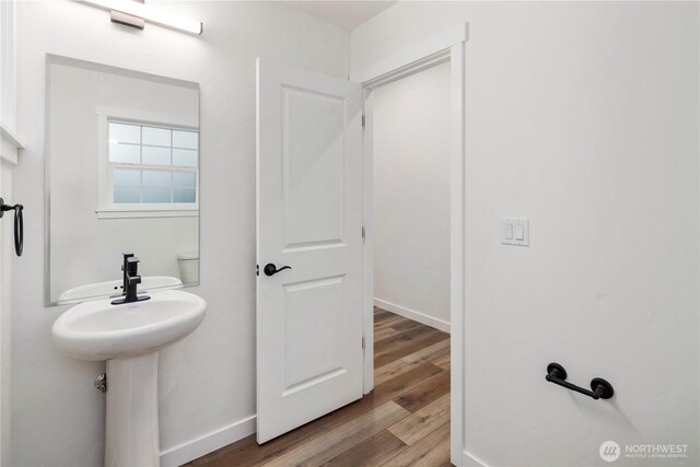 bathroom with baseboards and wood finished floors
