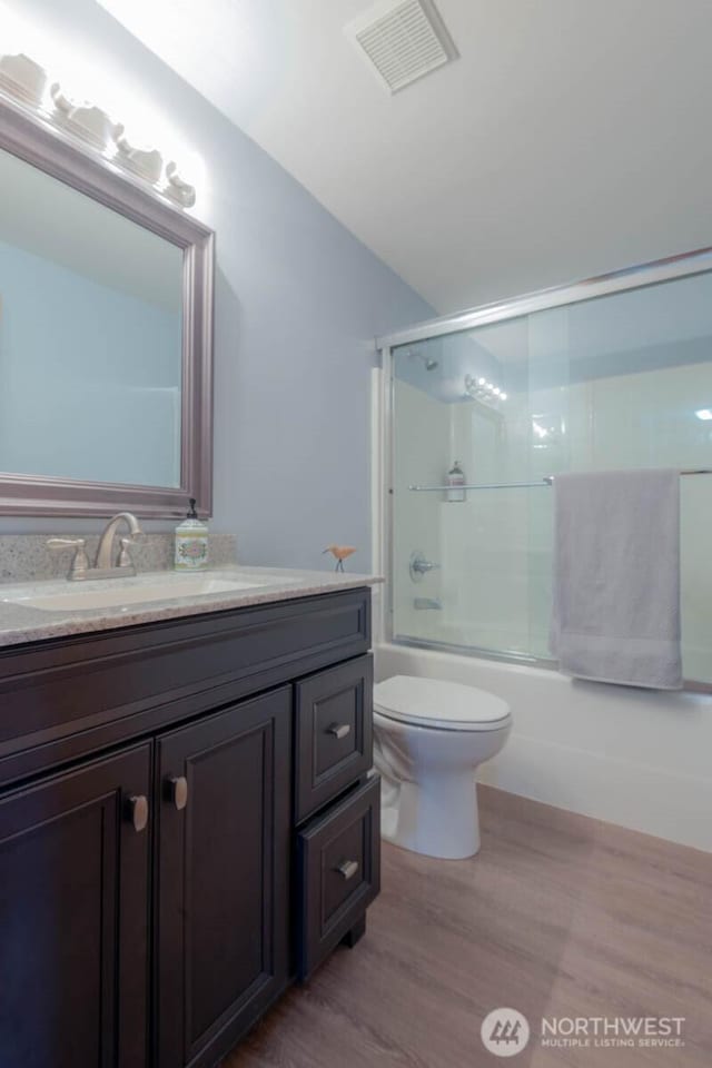121 E Connemara Way, Shelton, WA 98584 - full bath with wood finished floors, vanity, combined bath / shower with glass door, toilet, and lofted ceiling