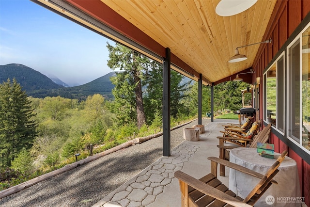 view of patio / terrace with a forest view and a mountain view