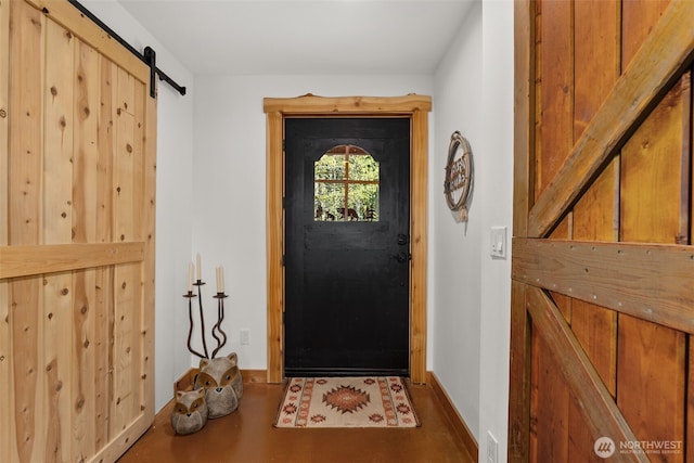 doorway to outside featuring baseboards and a barn door