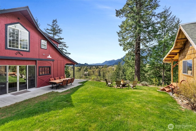 view of yard featuring a patio area, a mountain view, and an outdoor fire pit