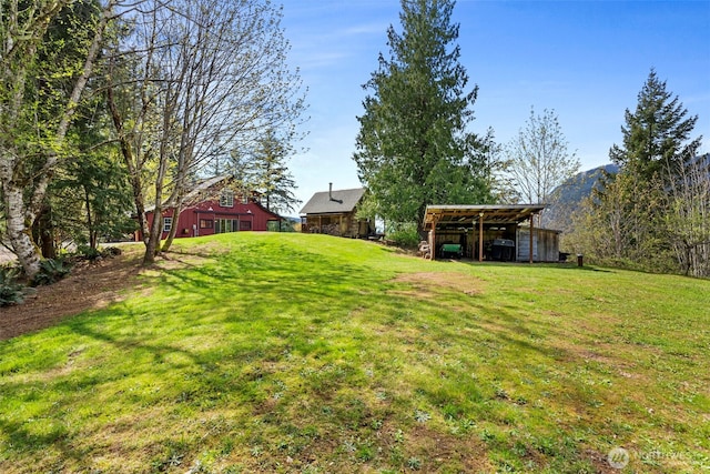 view of yard featuring an outdoor structure and an outbuilding