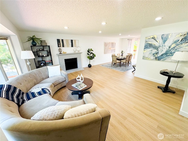 27526 26th Ave S, Federal Way, WA 98003 - living room with a textured ceiling, recessed lighting, light wood-style floors, baseboards, and a brick fireplace