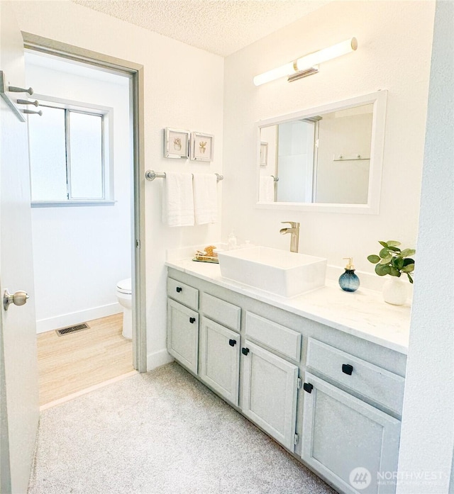 27526 26th Ave S, Federal Way, WA 98003 - bathroom with vanity, toilet, a textured ceiling, and baseboards