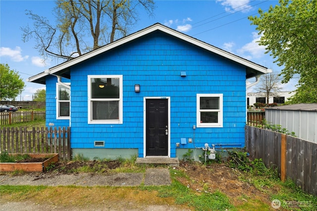 view of front of home with a garden, fence, and crawl space