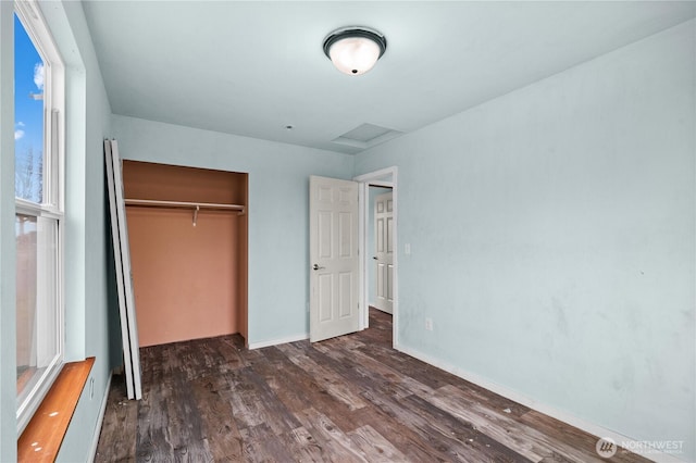 unfurnished bedroom with baseboards, wood finished floors, and a closet
