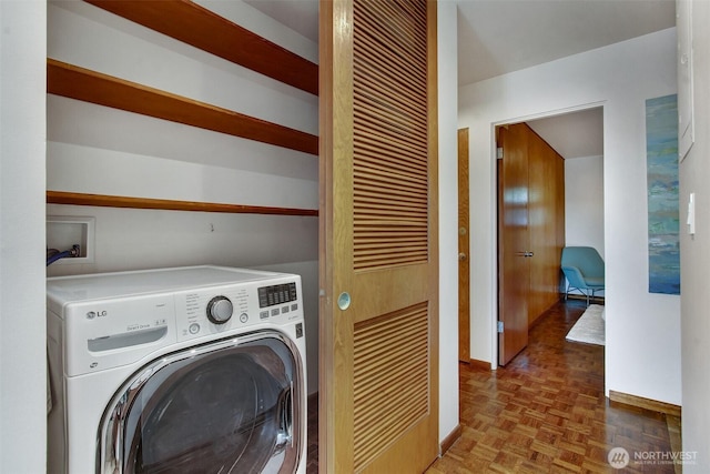 laundry room featuring baseboards, laundry area, and washer / clothes dryer