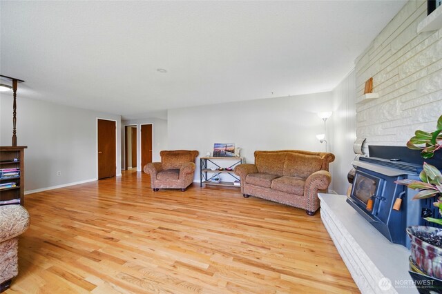 living area with a wood stove and light wood-style flooring
