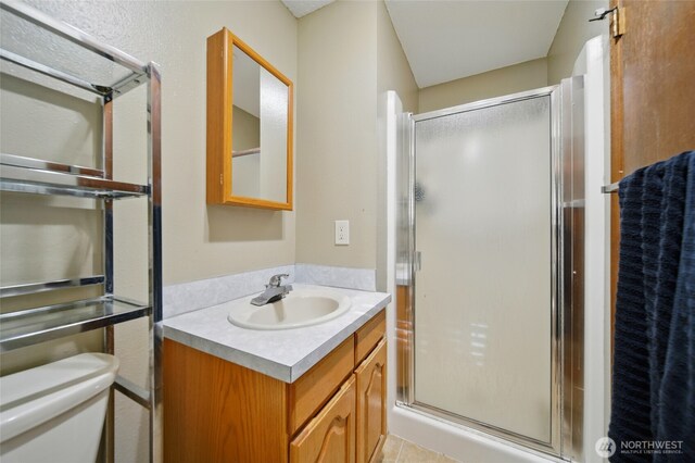 full bathroom with vanity, a stall shower, and toilet