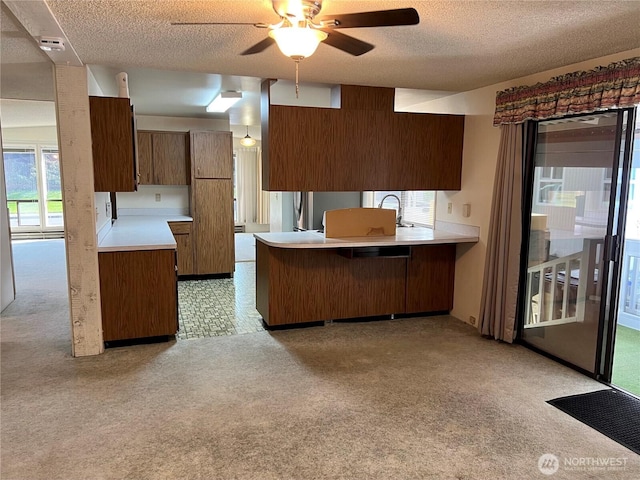 610 W Spruce St, Sequim, WA 98382 - kitchen with a peninsula, light countertops, a textured ceiling, and light carpet