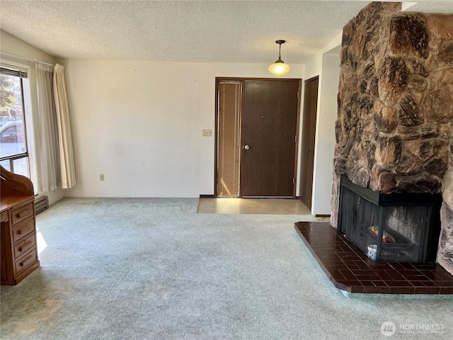 610 W Spruce St, Sequim, WA 98382 - unfurnished living room featuring a baseboard heating unit, carpet flooring, a fireplace, and a textured ceiling