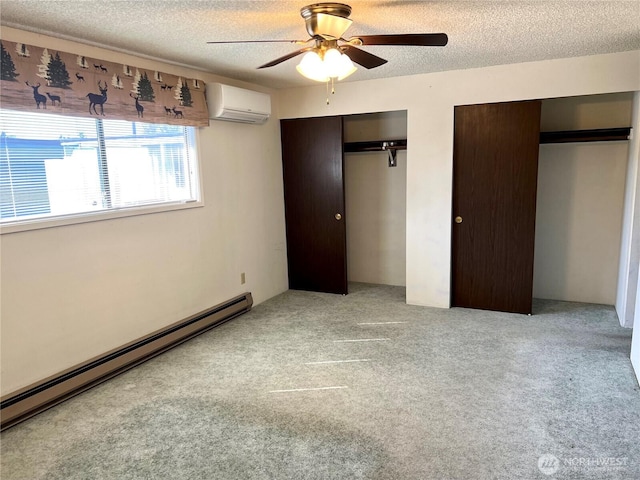 610 W Spruce St, Sequim, WA 98382 - unfurnished bedroom featuring a baseboard radiator, a textured ceiling, an AC wall unit, and multiple closets