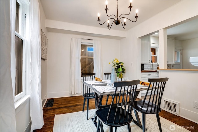 dining space featuring dark wood-style flooring, a chandelier, and visible vents