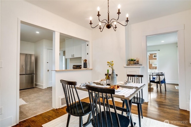 dining area featuring an inviting chandelier, baseboards, and wood finished floors