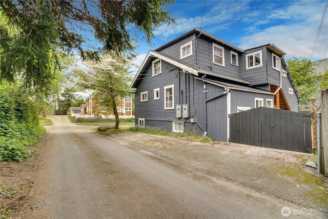 view of side of property with fence and a gate