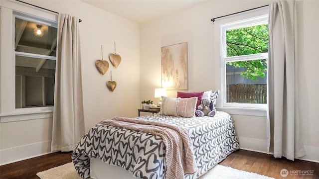 bedroom with baseboards and wood finished floors