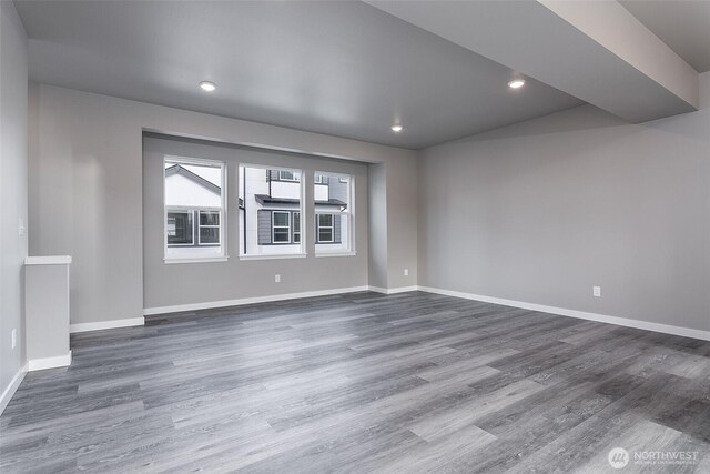 empty room with baseboards, recessed lighting, and dark wood-style flooring