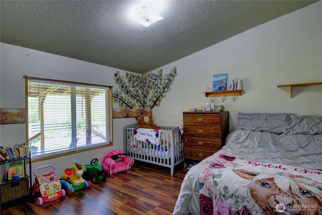 bedroom with a textured ceiling and wood finished floors