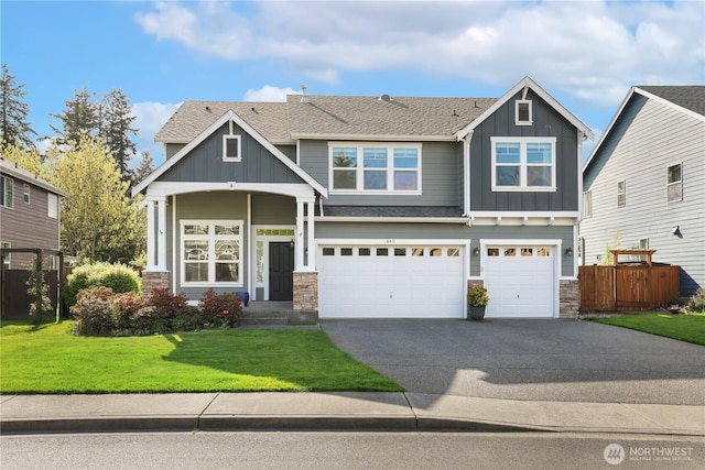 craftsman inspired home featuring concrete driveway, stone siding, board and batten siding, an attached garage, and fence