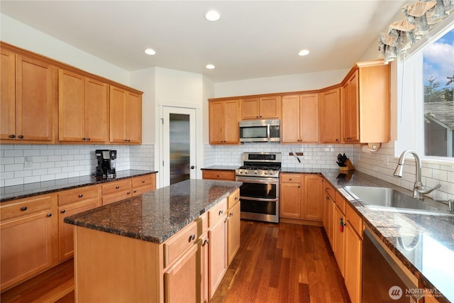 kitchen with dark wood-style flooring, appliances with stainless steel finishes, tasteful backsplash, and a sink